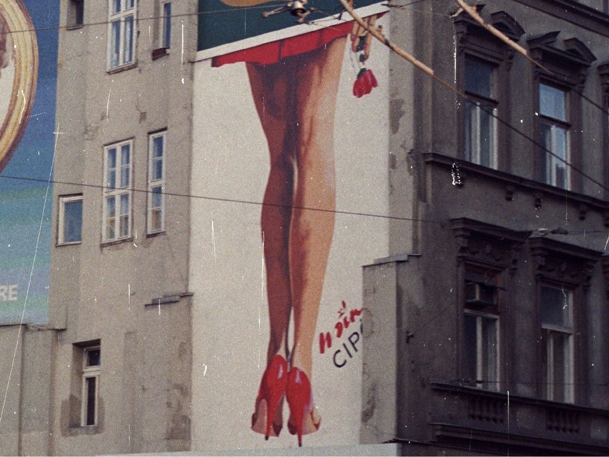 Vörös színű magassarkú Mino cipő reklámja 1985-ből a Kálvin tér házfalán