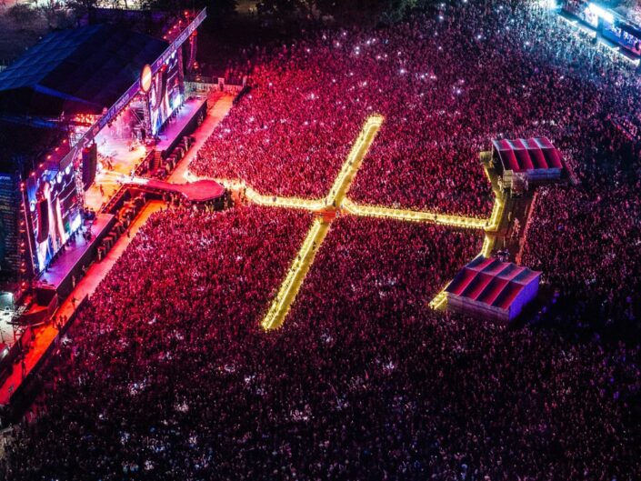 A Sziget Fesztivál nagyszínpada este piros fényben drónfelvételről – több tízezer ember van a színpad előtt