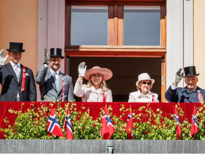 Norvég királyi család ünnepi eseményen erkélyről integet: Haakon koronaherceg, Mette-Marit, Szonja királyné és V. Harald király is a képen