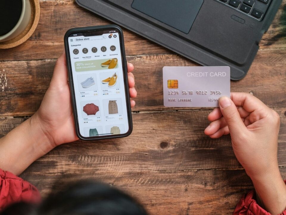 online-vasarlas-dopaminoldal - Nők Lapja Nő telefonján online boltban, másik kezében bankkártya