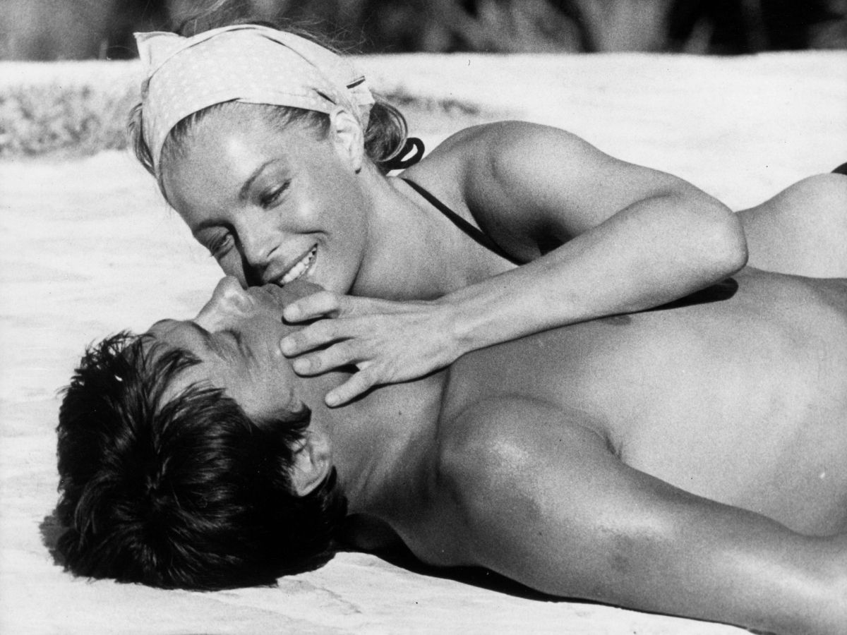 Romy Schneider és Alain Delon A medence című filmben tengerparton fekszik homokban