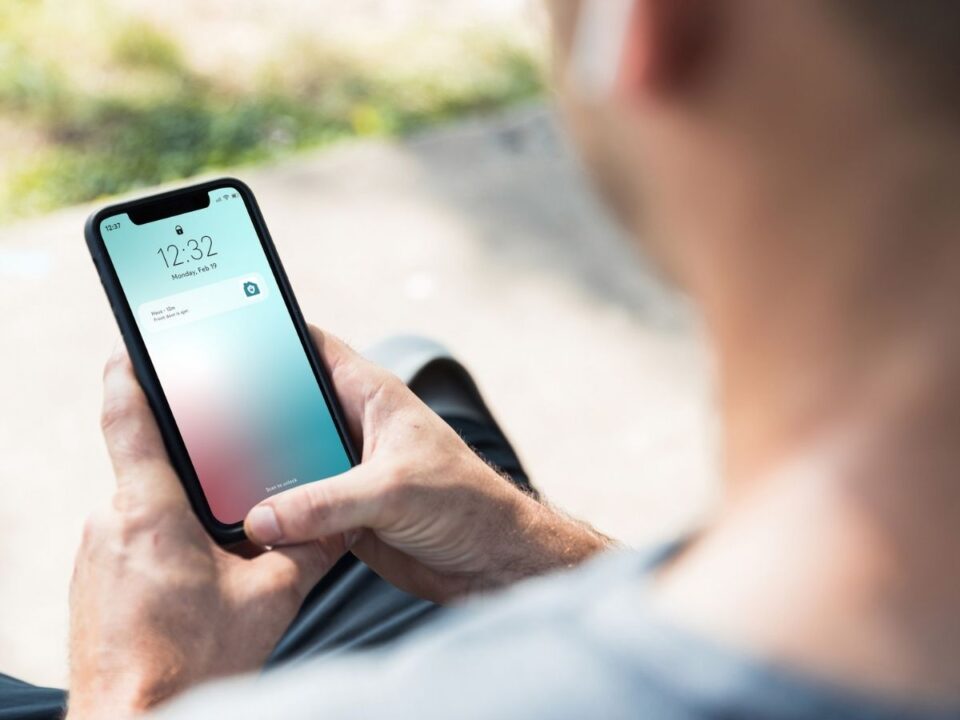 férfi nézi a telefonja kijelzőjét