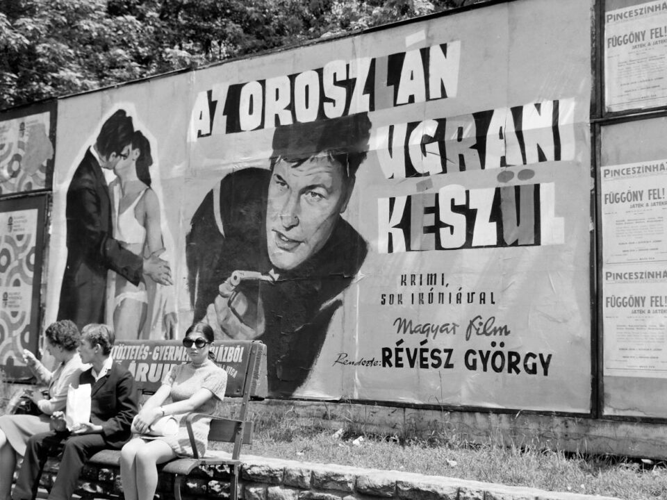 kviz-filmes-szalloigek - Nők Lapja Múzeum körút az Astoria kereszteződés közelében, a palánk mögött a metróépítés területe. A Fővárosi Moziüzemi Vállalat (FŐMO) által forgalmazott film plakátja.