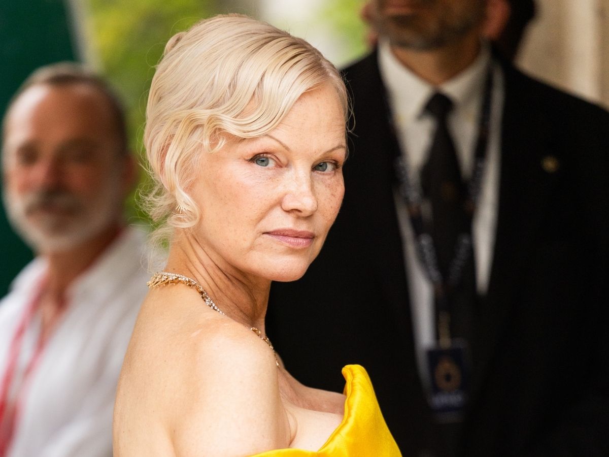Pamela Anderson kontyba kötött hajjal, láthatatlan sminkkel, sárga estélyiben érkezik a velencei filmfesztiválra