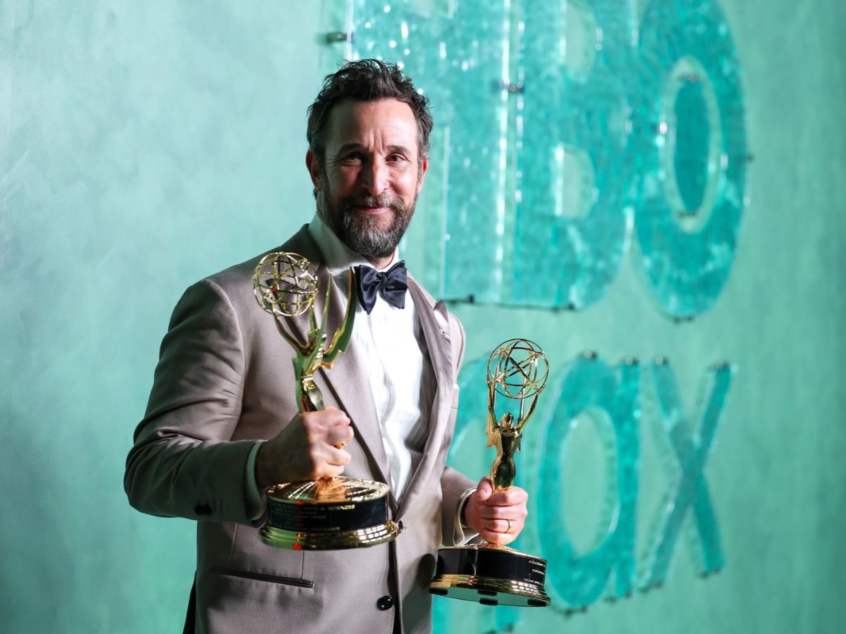 Noah Wyle az Emmy-díjakkal a kezében zöld háttér előtt