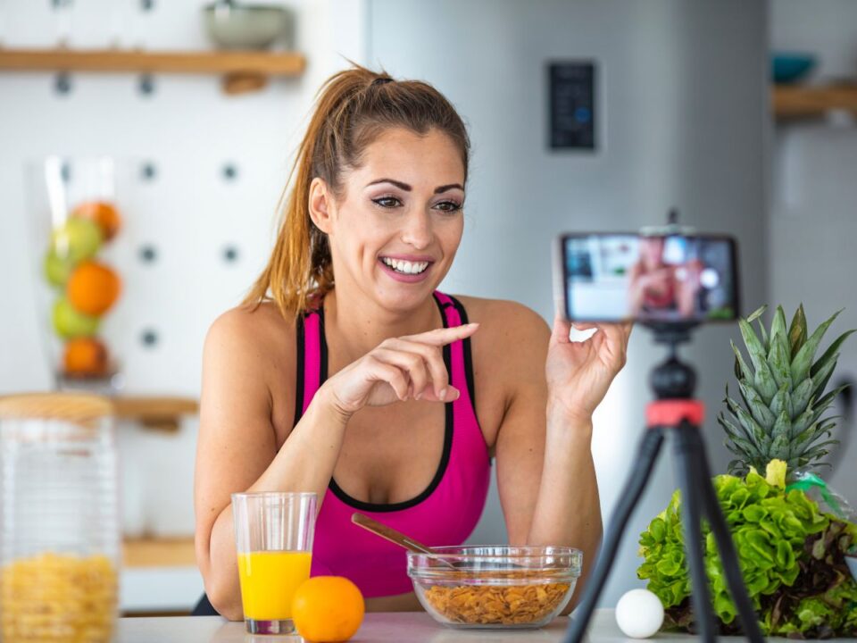 influenszer nő atlétában a reggelije közben készít felvételt