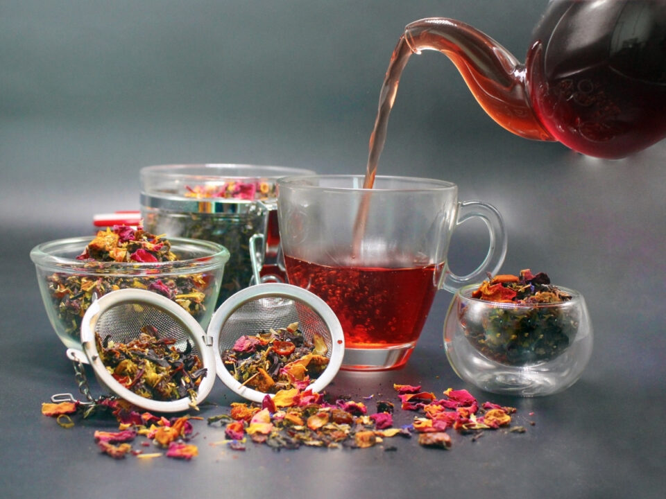 vorosszololevel-tea-labdagadas-ellen - Nők Lapja Gyógynövény teát öntenek üveg kiöntőből pohárba, mellette a teafű szűrőben és kis tálkában
